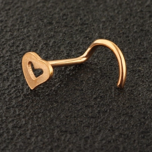 Macro detail of rose gold heart-shaped L-bend nose stud made of stainless steel