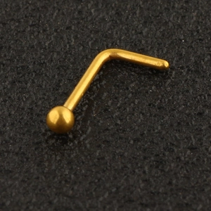 Macro detail of a polished golden stainless steel L-shaped nose stud with a ball top