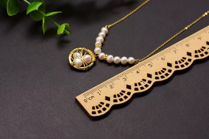Macro shot of bird nest pearl pendant necklace with scale ruler for size reference