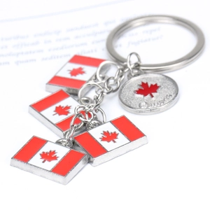Macro detail of zinc alloy Canada flag keyrings with red enamel pendants and maple leaf charm