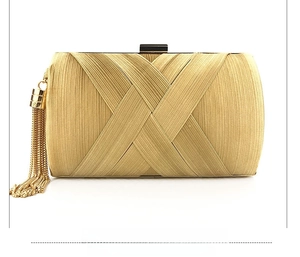 Detail view of the pleated golden satin clutch bag featuring a long side silk tassel