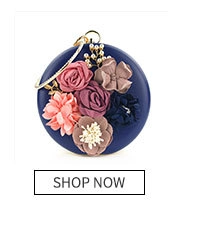 Detail of round navy evening clutch with colorful fabric flowers and pearl accents