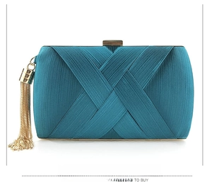 Detailed view of the turquoise satin clutch with pleats, gold frame, and stylish tassel