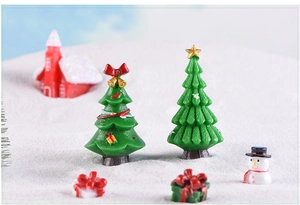 Miniature Christmas tree and snowman figurines on artificial snow for holiday decor