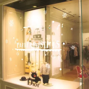 White Merry Christmas window decals with snowflakes and reindeer on a glass storefront