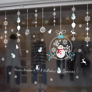 Christmas window decals with snowmen, reindeer and snowflakes on a shop glass front