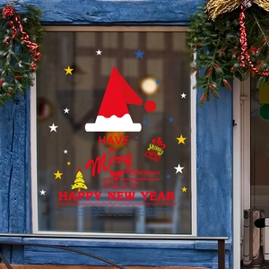 Christmas window decals with red hats and Merry Christmas text on blue glass panes