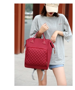 Detail of red quilted nylon diaper bag with front pocket shown on female model