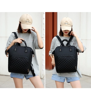 Detail of black quilted nylon diaper backpack with durable texture and spacious design
