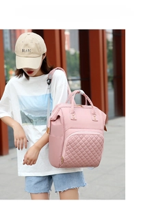 Pink waterproof nylon diaper backpack with quilted front pocket and large doctor-bag opening