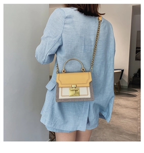 Model wearing stylish yellow color-block crossbody bag with gold chain and top handle