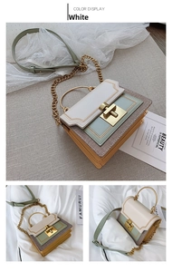 Detail view of tri-color patchwork handbag with golden ring handle and chain strap