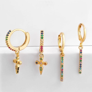 Detail of gold-plated hoop earrings with cross and bar charms featuring colorful zircons