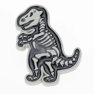 Detailed close-up of T-Rex dinosaur skeleton lapel pin with black and white enamel finish