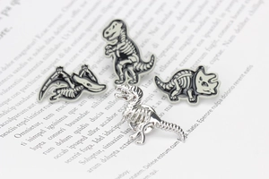 Detail view of 4 pieces dinosaur skeleton enamel lapel pins in zinc alloy finish