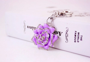 Detail of purple enamel rose keychain with sparkling rhinestones on silver metal chain