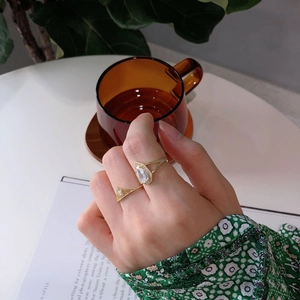 Detailed view of adjustable gold sterling silver ring with pear-shaped zircon on a hand