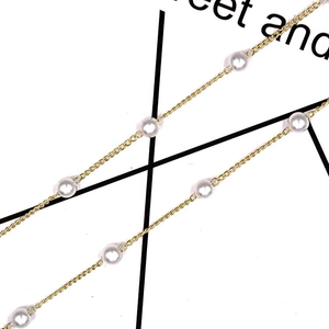 Minimalist gold link chain eyewear strap featuring elegant white pearls on a light background