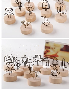 Detailed view of various metal wire photo clip shapes on vintage wooden bases