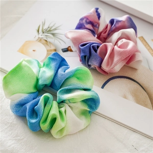 Detailed view of tie-dye gradient scrunchies in blue-green and pink-purple crepe fabric