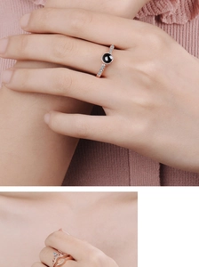 Detail showing two rose gold crown rings with black gemstone on model's hand