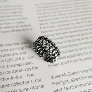 Detail of vintage 925 silver ring featuring braided texture and oval metal beads