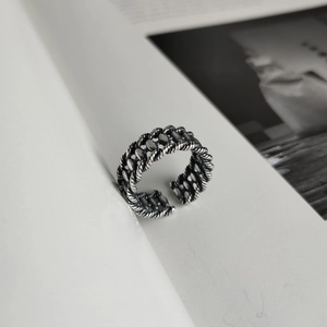 Macro detail of retro oxidized silver woven chain ring with adjustable open band