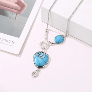 Bohemian silver necklace with blue turquoise snail pendant on white display stand