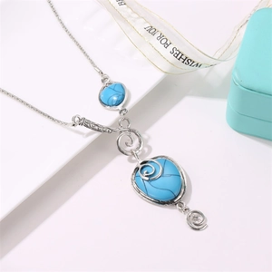 Detail view of Bohemian silver necklace featuring turquoise stones and spiral carvings