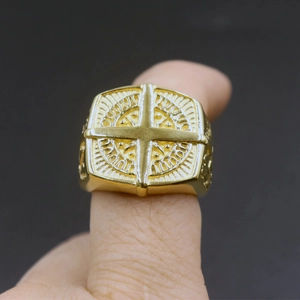 Macro shot of gold Masonic ring with cross relief pattern worn on finger