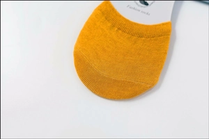 Macro shot of ginger yellow cotton knit toe detail with fashion socks branding