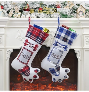 Dog paw Christmas stockings with photo slots hanging on fireplace with festive decor