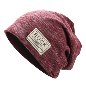 Detail of burgundy marl knit beanie showing the Rock patch and ribbed fabric texture