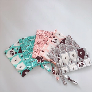 Flat lay of five cotton pouches with cute animal prints and secure tie-up straps