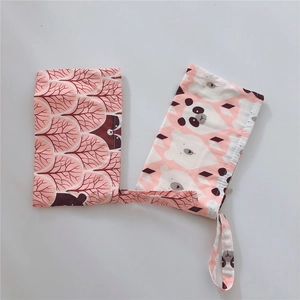 Detail of portable cotton pouches featuring cute raccoon and bear prints with handles