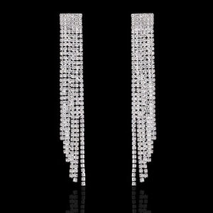 Close-up of elegant silver tassel drop earrings with sparkling zircon stones on black background