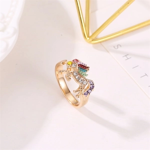 Close-up of golden unicorn ring with colorful rhinestones and white zircon setting