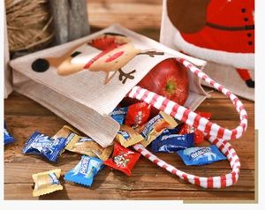 Close-up of burlap Christmas gift bag with 3D reindeer embroidery on wood table