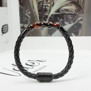 Detail of black braided leather bracelet with tiger eye beads and magnetic clasp closure