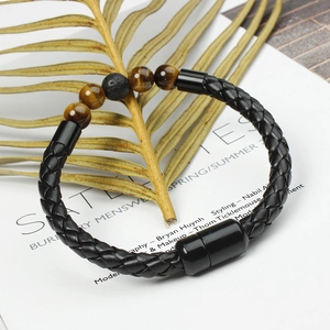 Detail of men's leather bracelet with tiger eye beads and magnetic clasp on magazine
