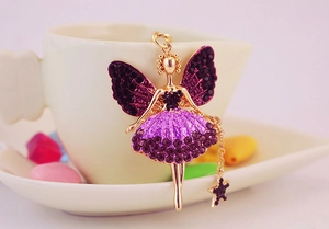 Détail du pendentif ange avec strass violets et ailes dorées sur une tasse à café