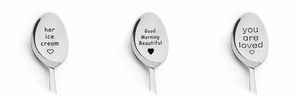 Detail view of engraved stainless steel spoons with heart patterns and custom text