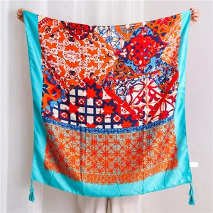 Detail of bohemian silk scarf with vibrant geometric patterns and soft blue tassels