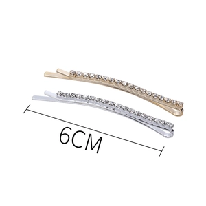 Macro detail of 6cm gold and silver hair clips featuring sparkling rhinestone row inlay