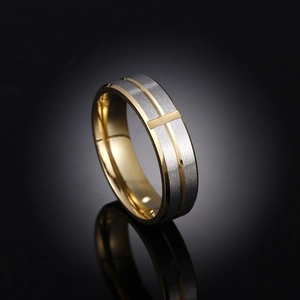 Detail of two-tone stainless steel ring with brushed finish and cross pattern decoration
