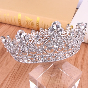 Close-up of silver bridal crown with intricate crystal rhinestones on a display stand