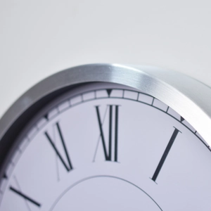 12-inch stainless steel wall clock with brushed metal frame and Roman numeral dial