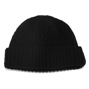 Close-up of classic black ribbed knit beanie showing thick vertical texture and folded cuff