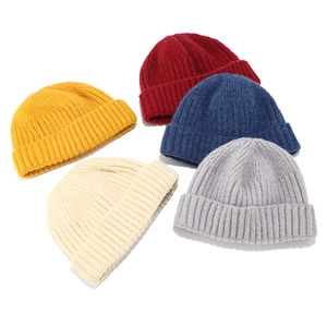 Detail showing various colors of ribbed knit beanies in yellow, red, blue, and grey