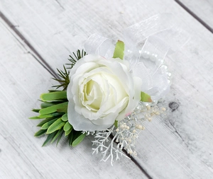 Dettaglio del fiore all'occhiello con rosa bianca, foglie e bracciale di perle
